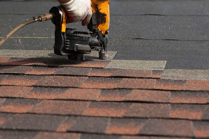 Roofer repairing asphalt roofs in Denver, CO