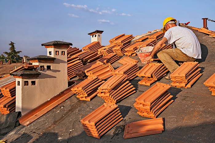 man installing tile roof