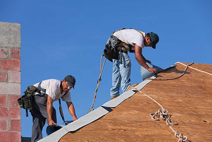 Worker installing roof in Denver, CO